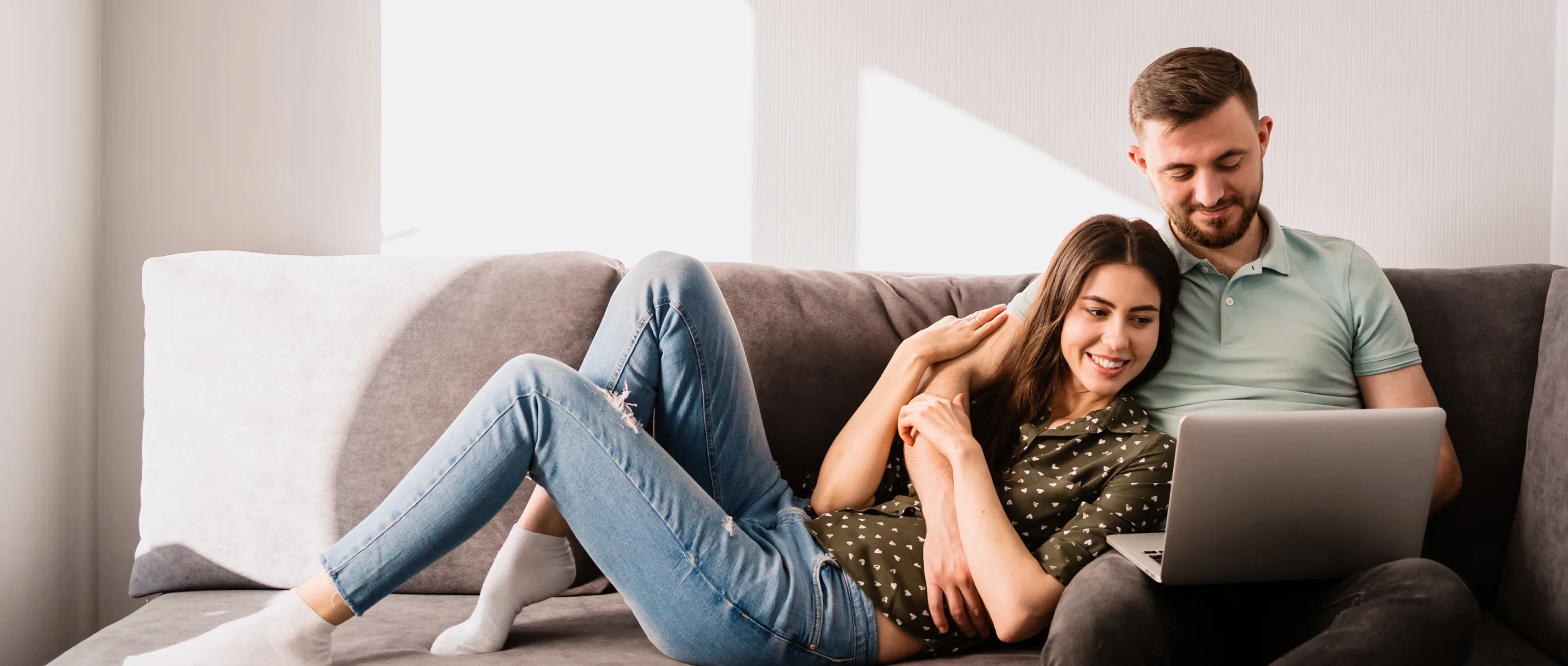 Man and woman sitting on a sofa with laptop